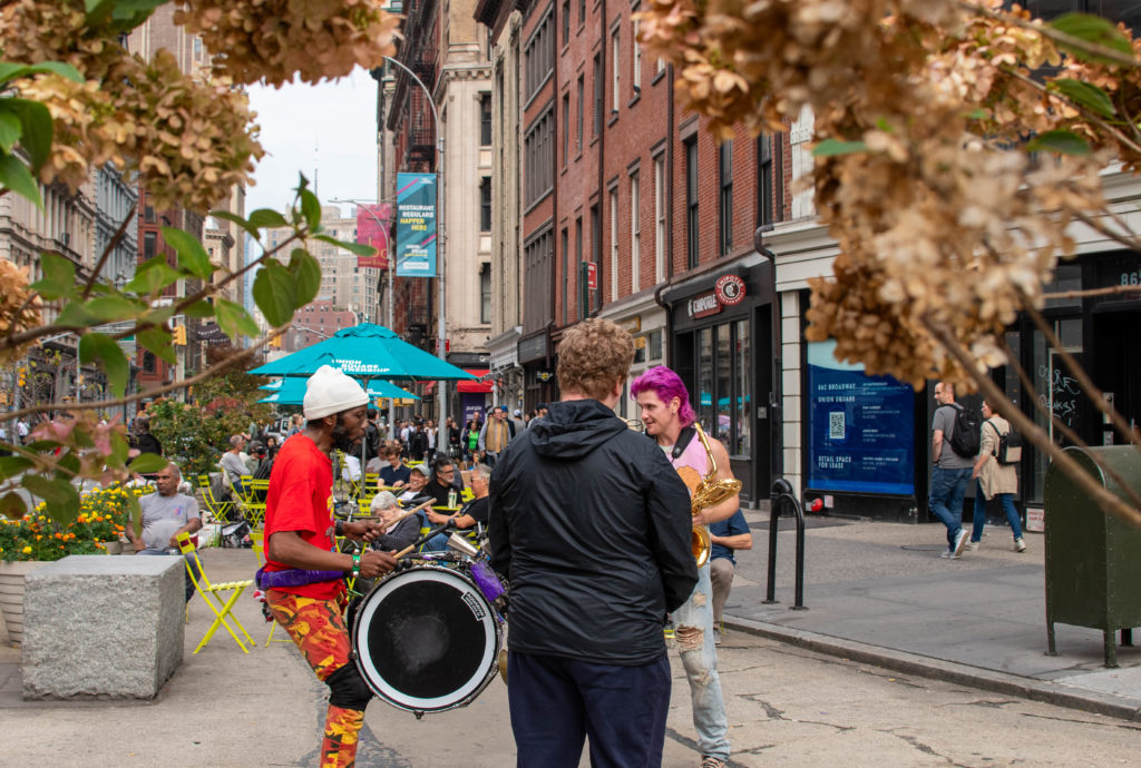 Too Many Zooz Trumpet Player Matt "Doe" Murihead, Baritone Saxophone Player Leo Pellegrino, and Drummer David "King of Sludge" Parks performing in Union Square