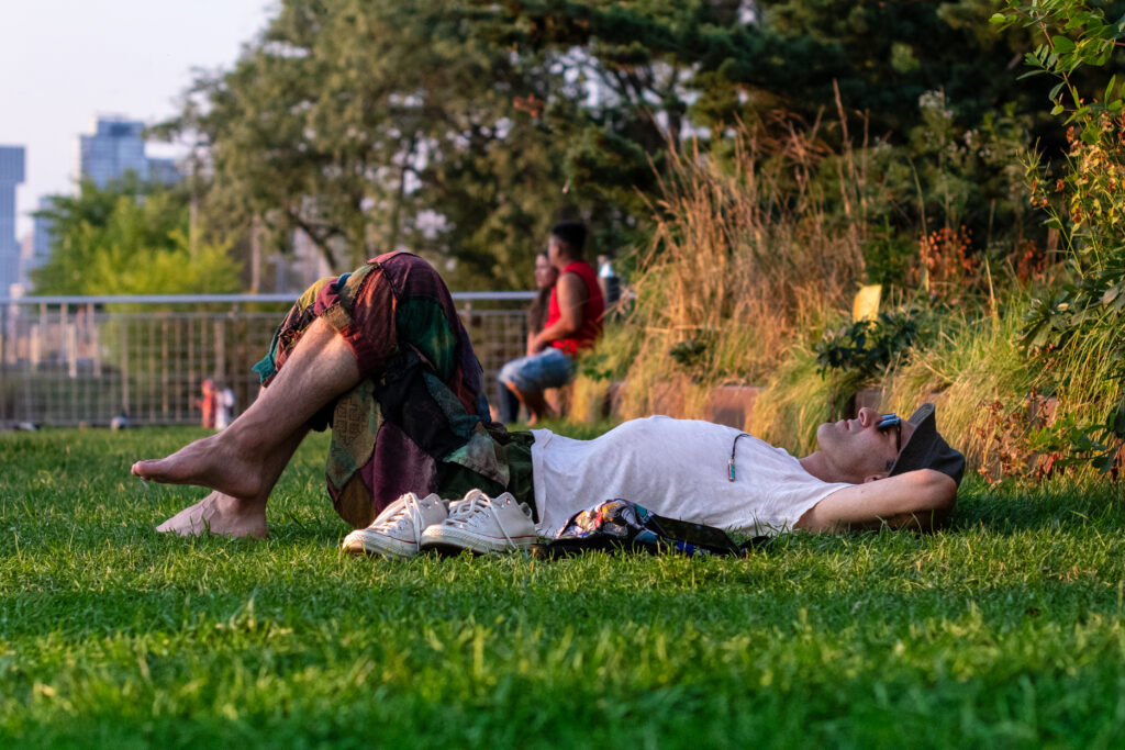 Man laying out on the grass at sunset